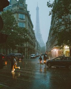 people walking in the rain with umbrellas near the eiffel tower