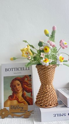 a vase filled with flowers sitting on top of a table next to books and magazines