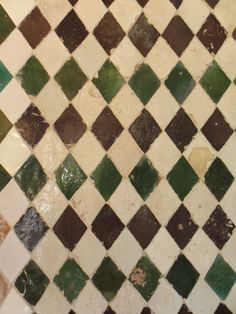 a close up of a tiled floor with green and white tiles on it's sides