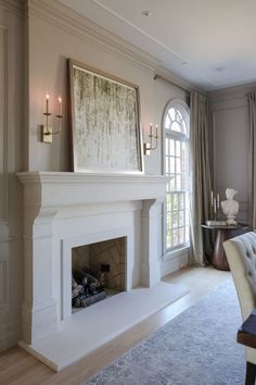 a living room filled with furniture and a fire place in front of a large window