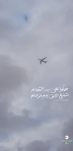 an airplane flying in the cloudy sky with arabic writing on it's back side