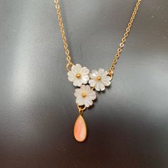 This Is A Lovely Vintage Cherry Blossom Necklace. The Flowers Are Carved Mother Of Pearl With A Coral Teardrop Dangle. Chain And Setting Are 12 Karat Gold Filled. 16” Length New Dead Stock From A Closed Jewelry Store From The 80’s. White Teardrop Necklaces For Mother's Day, Delicate White Flower Necklace For Anniversary, White Teardrop Necklace For Mother's Day, Dainty White Flower Necklace For Anniversary, White Dangle Necklaces For Mother's Day, Valentine's Day Yellow Gold Flower Necklace, Cameo Choker Necklace, Cherry Blossom Pendant Gold, Delicate Pink Flower-shaped Necklace