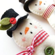 two snowmen with hats and buttons on them