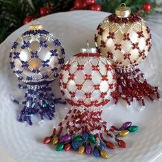 three glass ornaments are sitting on a plate