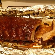 ribs covered in bbq sauce sitting on top of tin foil