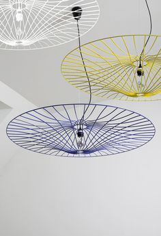 three blue lights hanging from the ceiling in a room with white walls and flooring