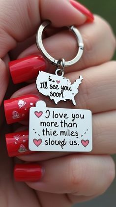 someone is holding two key chains that say i love you more than the miles they slay us