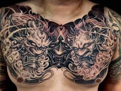 a man with tattoos on his chest is wearing a dragon and tiger tattoo design in front of his chest