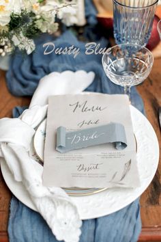 a place setting with blue napkins and silverware