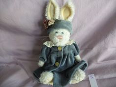 a stuffed rabbit wearing a blue coat and hat