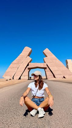 a woman sitting in the middle of an empty road