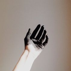 a person's hand reaching up into the air with their left hand in the air