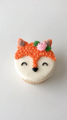 a cupcake shaped like a fox with flowers on its head