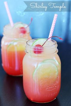 two mason jars filled with drinks sitting on top of a table