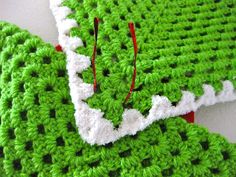 two crocheted pieces of green and white yarn are laying on top of each other