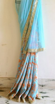 "A dreamy blue saree from Gia. The saree with its perfect blue of a clear summer sky and gold accents is a perfect addition to your wardrobe. The very pretty soft blue is perfectly complemented by the dull gold blouse which will make your skin look absolutely radiant. The bottom part of the saree is an azure blue floral fabric with pale rust coloured flowers. The top part is soft tulle with gold stones all over. Saree: semi silk 5.5 meters Blouse: 1 meter 44\" wide Shipping: Ships in 1-2 days of Blue Floral Saree, Blue Floral Fabric, Floral Saree, Gold Blouse, Perfect Blue, Blue Saree, Summer Sky, Soft Tulle, Azure Blue