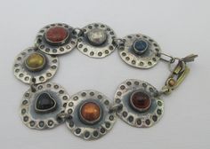 Awesome sterling silver bracelet with a modernist industrial look. I believe the bracelet is artisan (hand) made and each disc has each a different material: lapis lazuli, red jasper, copper, brass, onyx heart and amber (amber tested with UV light). Very unique and elegant. Statement piece. Some patina on it. Marked AS. Tested as sterling silver. Measurements: approx. 7.7 inches long & approx.0.9 inches in diameter Please note that due to lighting effects, monitor's brightness, contrast and othe Handmade Metal Modernist Bracelets, Handmade Modernist Metal Bracelets, Modernist Handmade Bracelets As Gifts, Artistic Silver Metal Bracelets, Modernist Adjustable Round Bracelets, Adjustable Round Modernist Bracelets, Disc Bracelet, Work Jewelry, Funky Jewelry