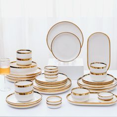 a table topped with white and gold plates