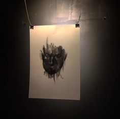 a black and white photo hanging on a wall in a dark room with a light