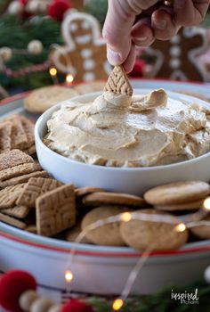 a person dipping crackers into a bowl of dip