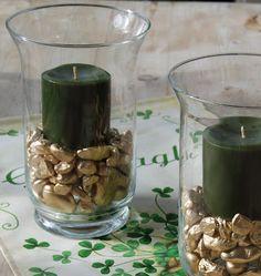 two glass vases filled with green candles