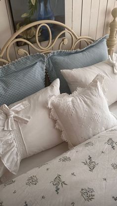 a bed with white and blue pillows on it