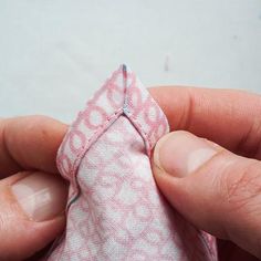 someone is stitching the end of a piece of fabric with their thumbnails