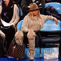 the singer is seen sitting in the stands at a basketball game