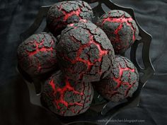 a bowl filled with black and red cookies on top of a table