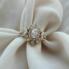 a diamond ring sitting on top of a white cloth