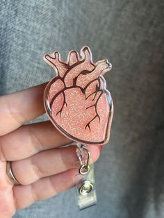 a person holding a heart shaped badge in their hand