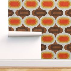 an orange, brown and white wallpaper with circles on it in the corner of a room