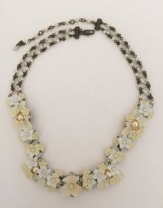 This is our garland necklace in a mix of colors of white and cream with glass beads and glass pearl accents. The flowers are hand painted resin and the entire necklace is beaded with thread and wire. The neck chain is also beaded. Pretty for a bride or could even be worn with a vintage white suit. Earrings on the model are also available. This is a quality piece of jewelry that will last a life time. Created by designer Colleen Toland who has been creating her unique style of vintage jewelry for White Flower-shaped Mother Of Pearl Necklace, White Pearl Beaded Costume Necklaces, White Beaded Flower Necklace, White Beaded Pearl Necklace Costume Jewelry, Handmade Vintage White Necklace, White Beaded Pearl Costume Necklace, Vintage Cream Flower Jewelry, White Bohemian Flower Necklace, Elegant Handmade White Flower Necklace