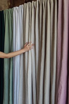 a woman's hand is on the curtain with her hands in front of it