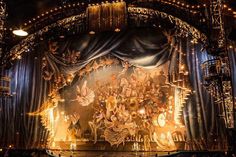 the stage is decorated with an elaborately detailed painting on it's curtained walls