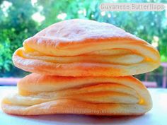 a stack of pancakes sitting on top of each other in front of a green tree