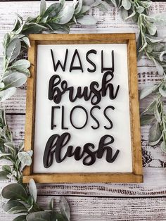 a sign that says wash brush floss flush in black letters on a white wooden background