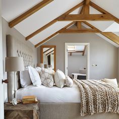 a large bed sitting under a wooden beam in a bedroom