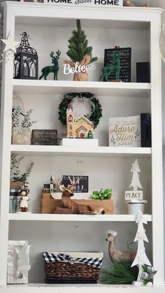 a white book shelf filled with christmas decorations