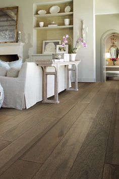 a living room with wood floors and white furniture