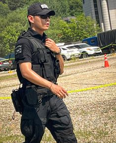 a police officer is standing in the grass with his hand on his chest and looking at something