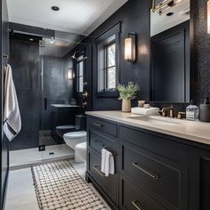 a black and white bathroom with gold accents