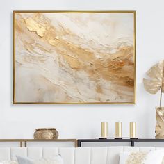 a living room filled with white couches and gold accents on the wall above them