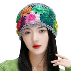 a woman wearing a multicolored crochet hat with flowers on it's brim