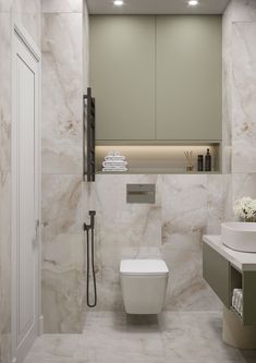 a white toilet sitting in a bathroom next to a sink