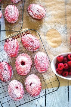 powdered donuts and raspberries sit on cooling racks, ready to be eaten