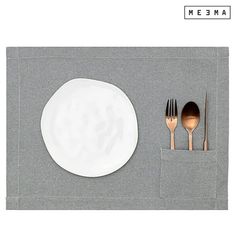 a place setting with silverware and napkins on a gray table cloth, next to a white plate