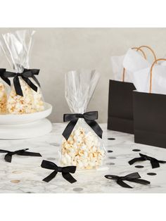 two bags filled with popcorn sitting on top of a table next to black and white polka dots