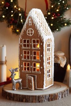 a gingerbread house is lit up with candles