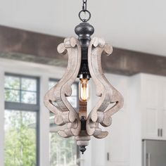 a chandelier hanging from the ceiling in a room with white walls and flooring